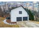 Rear exterior of home with 2-car garage, black trim and siding, and back deck at 4492 Bryten Dr, Douglasville, GA 30135