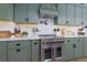 Modern kitchen with stainless steel range, green cabinets, and white quartz countertops at 4492 Bryten Dr, Douglasville, GA 30135