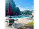Relaxing pool area with comfortable seating, shade umbrellas, and a refreshing view at 6196 Windflower Dr, Powder Springs, GA 30127