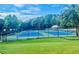 Community tennis courts with surrounding trees at 6196 Windflower Dr, Powder Springs, GA 30127