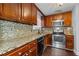 Galley kitchen with wood cabinets and granite countertops at 5667 Kingsport Dr, Atlanta, GA 30342