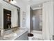 Modern bathroom with gray tile shower/tub, marble vanity, and gold fixtures at 6870 Colfax Ave, Cumming, GA 30040