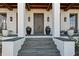 Covered porch with a double front door, stone flooring, and large planters at 6870 Colfax Ave, Cumming, GA 30040