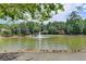 Serene pond view with a central fountain at 3495 Tulip Tree Ln, Duluth, GA 30096