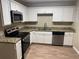 White kitchen cabinets, granite countertops, and stainless steel appliances at 3705 Daisy Dr, Decatur, GA 30032