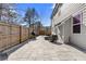 Stone patio with outdoor seating, a grill, and backyard view enclosed by a wooden fence at 2417 Kingston Heath Way, Marietta, GA 30008