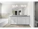 Bathroom featuring granite countertop double vanity, soaking tub, and glass enclosed shower at 2417 Kingston Heath Way, Marietta, GA 30008