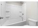 Bright bathroom features a white tub/shower combination with built in shelves and chrome fixtures at 2417 Kingston Heath Way, Marietta, GA 30008