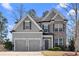 Charming two-story home featuring a two-car garage and a combination of gray siding and brick facade at 2417 Kingston Heath Way, Marietta, GA 30008