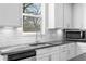 Well-lit kitchen boasts white cabinets, subway tile backsplash, and granite countertops at 2417 Kingston Heath Way, Marietta, GA 30008