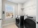 Well-lit laundry room equipped with modern washer and dryer and ample shelving for organization at 2417 Kingston Heath Way, Marietta, GA 30008
