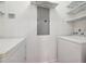 Bright laundry area with white washer and dryer, storage shelves, and modern electrical panel at 1101 Juniper Ne St # 415, Atlanta, GA 30309