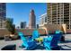 Relaxing rooftop terrace with blue Adirondack chairs and a city backdrop at 1101 Juniper Ne St # 415, Atlanta, GA 30309