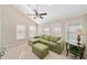 Bright sunroom with green sectional and large windows at 2440 Jamerson Rd, Marietta, GA 30066