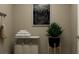 Clean laundry room with a hamper, shelf, and a decorative plant adding a touch of nature at 2801 Habibi Ct, Buford, GA 30519