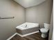 Bathroom featuring corner bathtub and toilet at 5464 Sierra Trl, College Park, GA 30349