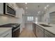 Open concept kitchen with island, stainless steel appliances, and light hardwood floors at 4822 Floydwood Ln, Mableton, GA 30126