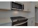 Stainless steel range and microwave above, white cabinets and quartz countertops at 4822 Floydwood Ln, Mableton, GA 30126