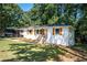 White brick ranch house with wood accents and a well-manicured lawn at 207 Okemah Se Trl, Marietta, GA 30060