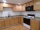 Kitchen features wood cabinets, granite counters, and stainless steel appliances at 1616 Oleander Sw Dr, Lilburn, GA 30047