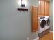 A laundry room with a hook rack, overhead cabinets, a washing machine, and a dryer at 1616 Oleander Sw Dr, Lilburn, GA 30047