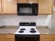 Black microwave installed above the stove at 1616 Oleander Sw Dr, Lilburn, GA 30047