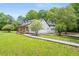 White farmhouse exterior with a wrap-around porch and landscaped yard at 4107 Old Suwanee Rd, Buford, GA 30518