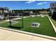 Community outdoor game area featuring cornhole, surrounded by lush artificial turf and modern architectural details at 1250 Winterhaven Dr, Cumming, GA 30041