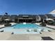 Stunning community pool with in-water lounge chairs, umbrellas, and clubhouse set against a backdrop of modern homes at 1250 Winterhaven Dr, Cumming, GA 30041