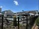 Community pool area with lounge chairs and umbrellas, surrounded by lush landscaping and wrought iron fence at 1250 Winterhaven Dr, Cumming, GA 30041