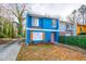 Cute blue renovated duplex with orange door, landscaping, and driveway at 2106 Childress Sw Dr, Atlanta, GA 30311