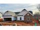 Newly constructed home boasts a charming exterior with stone accents and a two-car garage at 475 Charleston Pl, Villa Rica, GA 30180