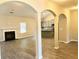 Bright living room with a fireplace, hardwood floors, and arched doorways leading to the kitchen at 475 Charleston Pl, Villa Rica, GA 30180