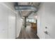 Long hallway with exposed ductwork and hardwood floors at 115 W Peachtree Nw # 704, Atlanta, GA 30313