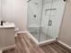 Modern basement bathroom featuring a large glass shower, marble, and vinyl flooring at 1590 Highland Farm Dr, Suwanee, GA 30024