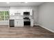 Modern basement kitchen with white cabinets, stainless steel appliances, and vinyl flooring at 1590 Highland Farm Dr, Suwanee, GA 30024