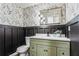 Powder room with stylish vanity, dark wainscoting, and leaf wallpaper at 2019 Emerald Dr, Jonesboro, GA 30236