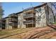 Apartment building with multiple levels of balconies and mature trees surrounding the property at 2201 Cumberland Se Ct, Smyrna, GA 30080