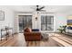 Cozy living area with a brown leather chair, a ceiling fan, large windows, and hardwood floors at 2201 Cumberland Se Ct, Smyrna, GA 30080