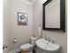 Small powder room with white pedestal sink, toilet and framed wall art at 3939 Glenview Club Ln, Duluth, GA 30097