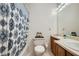 Clean bathroom with shower/tub combo, wood vanity, and patterned shower curtain at 1945 Brian Way, Decatur, GA 30033