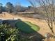 Putting green with pond and trees in background at 28 Glenald Nw Way, Atlanta, GA 30327