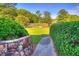 Pathway leading to tennis courts with stone wall and hedges at 28 Glenald Nw Way, Atlanta, GA 30327