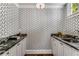 Stylish wet bar with geometric wallpaper and dark countertops at 500 Westover Nw Dr, Atlanta, GA 30305