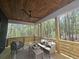 Inviting covered porch with a wooden ceiling fan, cozy seating, and scenic views of the lush greenery at 160 Cedarwood Ln, Roswell, GA 30075