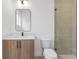 Modern bathroom with wood vanity, white countertop, rectangular mirror, and tiled shower at 160 Cedarwood Ln, Roswell, GA 30075