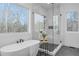 Bright bathroom featuring a modern tub, glass shower, and expansive window view at 160 Cedarwood Ln, Roswell, GA 30075