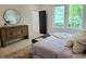 Stylish bedroom with a decorative dresser and view of lush greenery at 160 Cedarwood Ln, Roswell, GA 30075