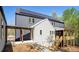 Back of home with a porch and stairs, modern siding, a gray roof with solar panels, and nice landscaping at 160 Cedarwood Ln, Roswell, GA 30075