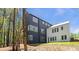 Modern three-story home showcases unique design, large windows, and landscaped yard, nestled among mature trees at 160 Cedarwood Ln, Roswell, GA 30075